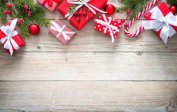 Sfondo natalizio con scatole regalo rosse su tavola di legno — Foto Stock