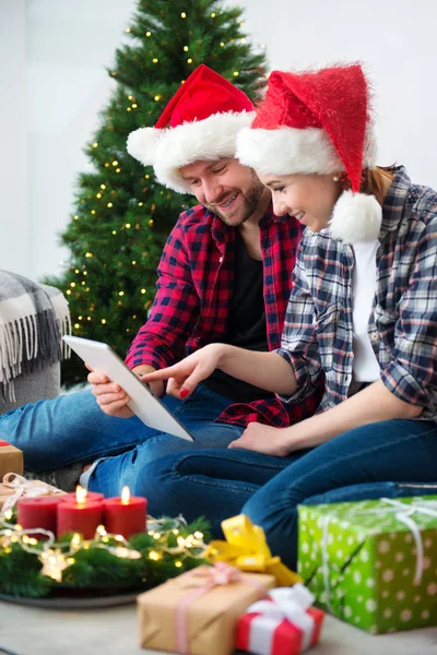 Junges Paar mit Weihnachtsmann-Hüten shoppen online Weihnachten gif — Stockfoto