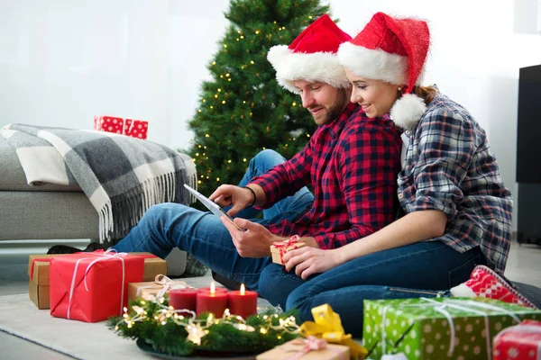 Junges Paar mit Weihnachtsmann-Hüten shoppen online Weihnachten gif — Stockfoto