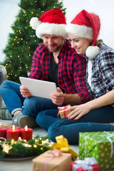 Junges Paar mit Weihnachtsmann-Hüten shoppen online Weihnachten gif — Stockfoto