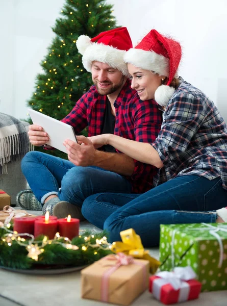 Junges Paar mit Weihnachtsmann-Hüten shoppen online Weihnachten gif — Stockfoto
