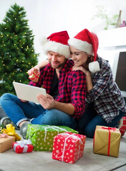 Junges Paar mit Weihnachtsmann-Hüten shoppen online Weihnachten gif — Stockfoto