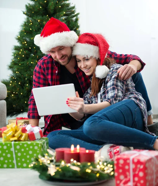 Junges Paar mit Weihnachtsmann-Hüten shoppen online Weihnachten gif — Stockfoto