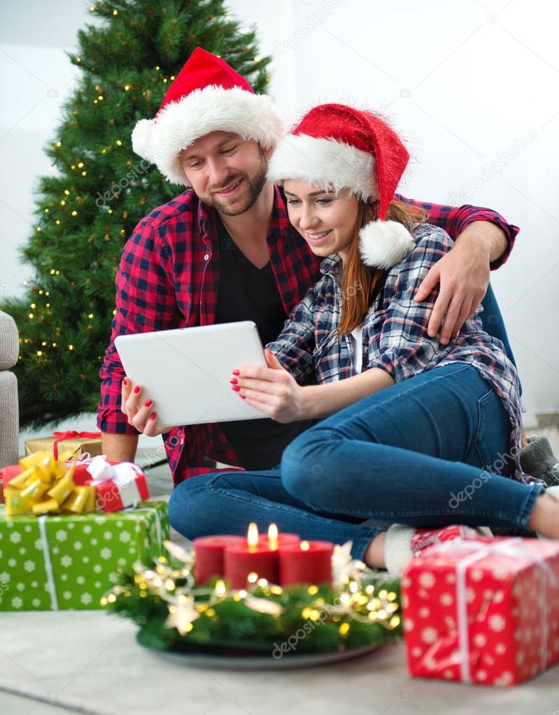 Young couple with Santa Claus hats shopping online Christmas gif