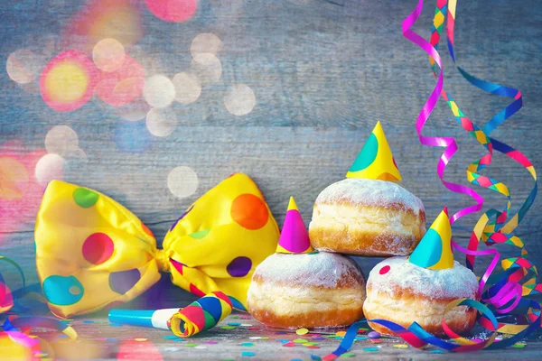 Donuts de carnaval con serpentinas de papel y pajarita de fiesta —  Fotos de Stock