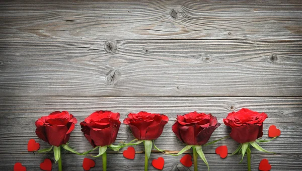Романтическая цветочная рамка с розами и сердцами на деревянном фоне — стоковое фото