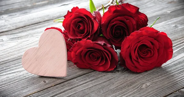 Romantica cornice floreale con rose e cuore su sfondo di legno — Foto Stock