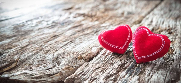 Dos corazones rojos sobre fondo rústico de madera — Foto de Stock