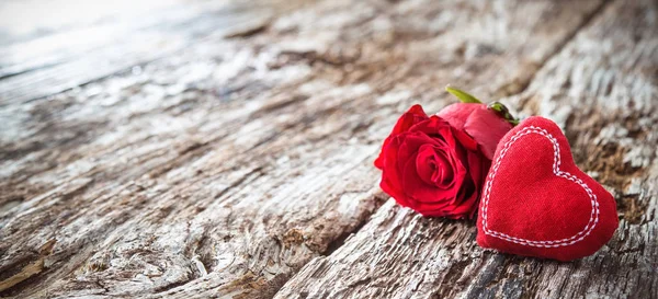 Corazón rojo con rosas sobre un fondo rústico de madera — Foto de Stock