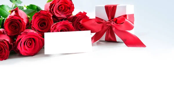 Ramo de rosas rojas y caja de regalo con etiqueta vacía —  Fotos de Stock