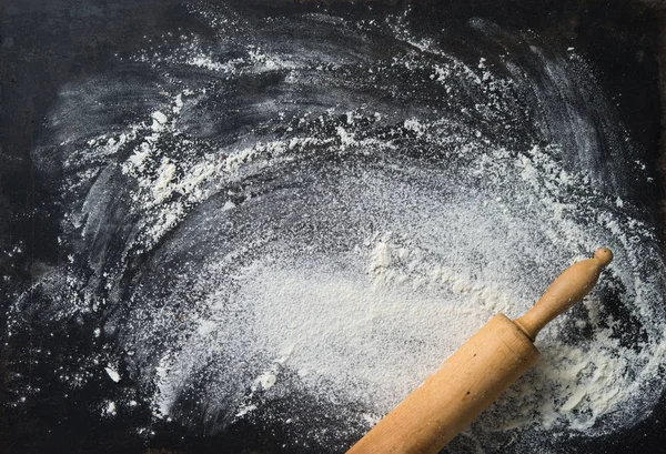 Baking background with the rolling pin and flour. On the dark ta — Stock Photo, Image