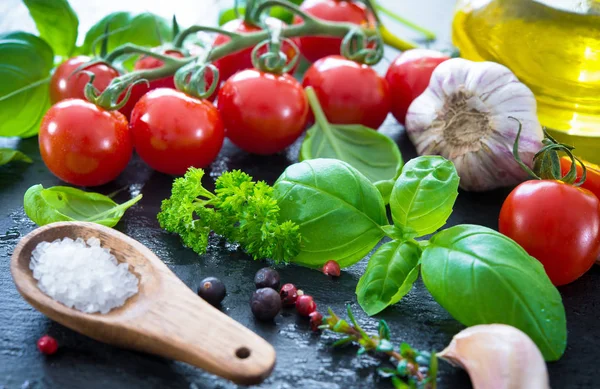 Ripe tomatoes with fresh basil, garlic and other herbs with wate — Stock Photo, Image