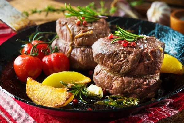 Juicy medium beef fillet steaks mignon in pan on table — Stock Photo, Image