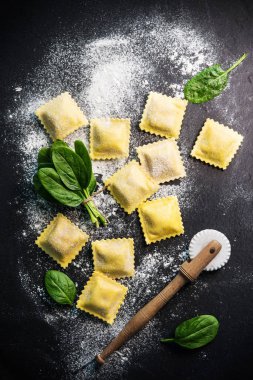 Ispanak ve ricotta koyu arka plan üzerinde ile mantı