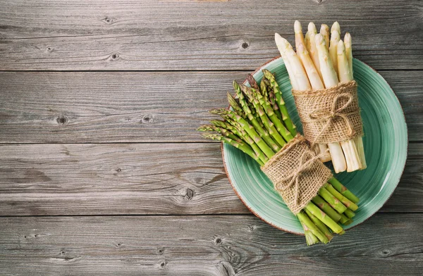 Mazzi di asparagi freschi verdi e bianchi su fondo di legno — Foto Stock