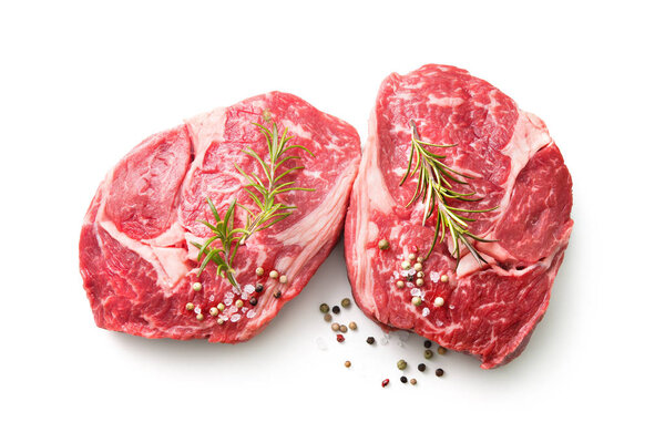 fresh raw rib eye steaks isolated on white background