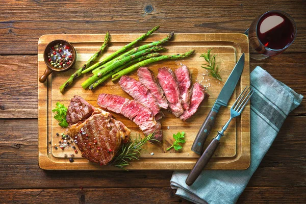 Bife de costela assado com espargos verdes e vinho — Fotografia de Stock