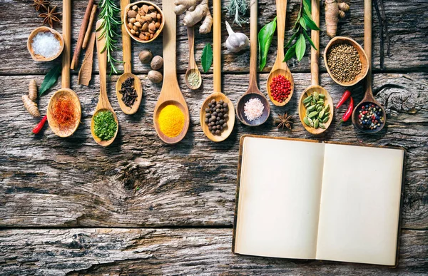 Olika örter och kryddor för matlagning på gamla träskiva — Stockfoto