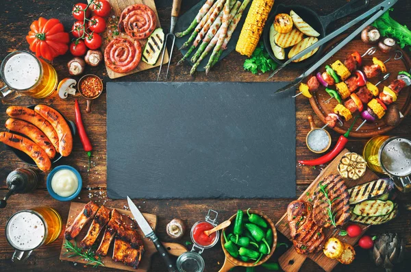 Grillowane mięso i warzywa na rustykalne drewniany stół — Zdjęcie stockowe