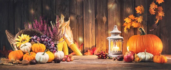 Calabazas con frutas y hojas que caen sobre mesa de madera rústica — Foto de Stock