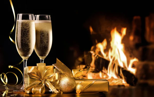 Two champagne flutes with gold gift boxes and streamers in front — Stock Photo, Image