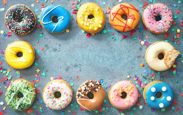 Festlicher Karneval oder Geburtstagsrahmen aus verschiedenen bunten Donuts — Stockfoto