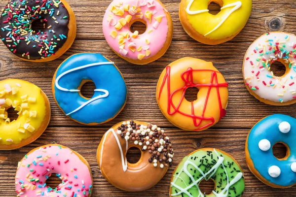 Verschiedene bunte Donuts auf hölzernen — Stockfoto