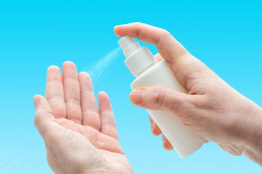 Antibacterial sanitizer spray for hands. Female hands using disinfection spray to prevent germs, bacteria or viruses  clipart