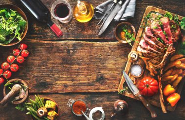 Izgara et, dilimlenmiş balta bifteği, baharatlar, patates kızartması ve kırsal alanda sebze.