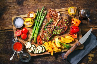 Izgara sebzeli biftek ve servis masasında baharat.