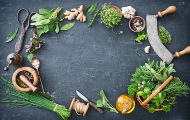 Bahçeden çeşitli taze otlar ve kırsal masada mutfak aletleri. Kopyalama alanı olan üst görünüm