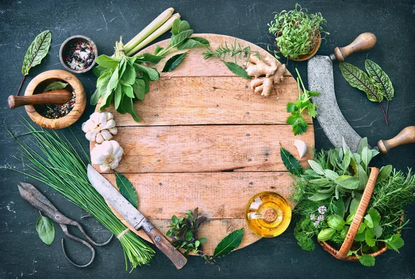 Various fresh herbs from garden with kitchen utensils on rustic table. Top view with copy space