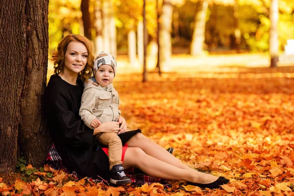 Glückliche Mutter und Sohn spazieren im Herbstpark — Stockfoto