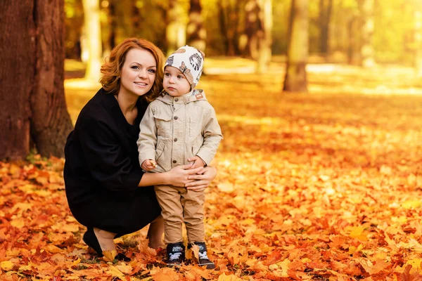 Felice madre e figlio stanno camminando nel parco autunnale — Foto Stock