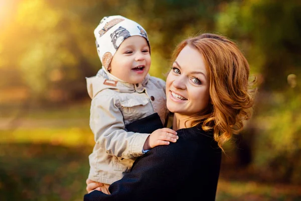 Glückliche Mutter und Sohn spazieren im Herbstpark — Stockfoto