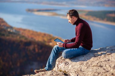 açık havada bir tablet üzerinde çalışan adam