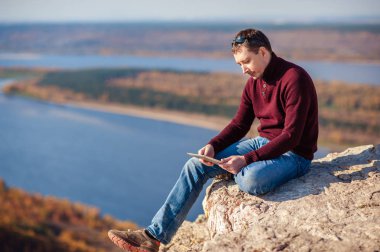 açık havada bir tablet üzerinde çalışan adam