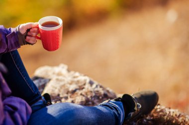 bir fincan çay tutan bir dağ kızı üstüne