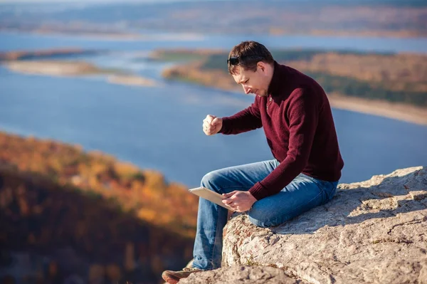 açık havada bir tablet üzerinde çalışan adam