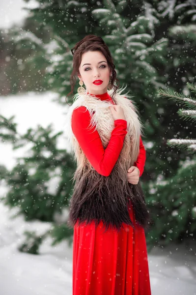穿红衣服的女孩在冬天的森林里漫步 — 图库照片