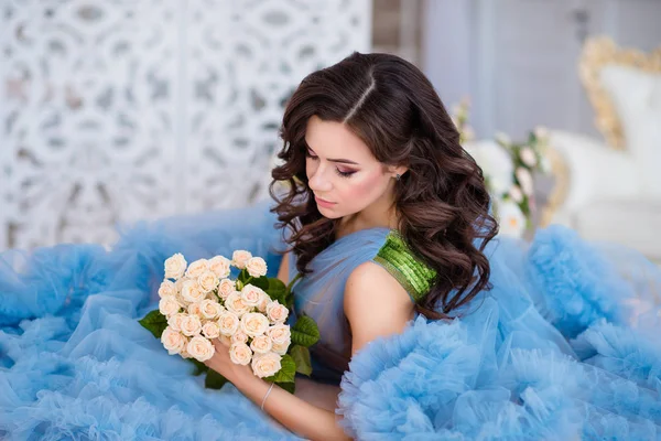bir blu ellerinde çiçeklerle koyu saçlı güzel kız