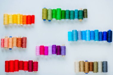 Dikiş için aksesuarlar. Beyaz arkaplanda beyaz bir tabutta renkli iplik makaraları