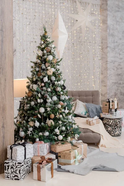 Yeni yıl için beyaz bir salonda hediyeleri olan büyük, güzel bir yeni yıl ağacı.