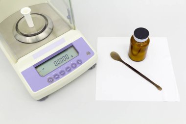 Laboratuvar tartısı şişelerde malzemelerle birlikte masada..
