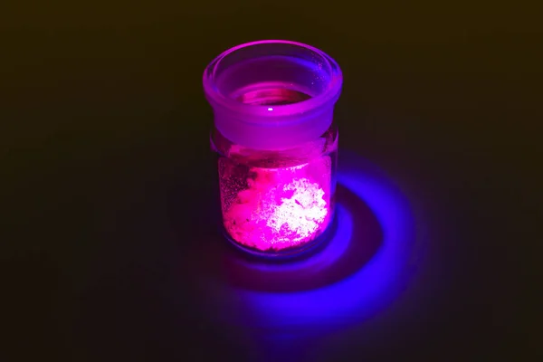 Fluorescent organic materials of red, yellow and green color for production OLED inside glass bottle in UV light.