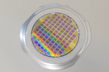 Silicon wafer with microchips fixed in the holder with steel frame on the grey background and ready for process . clipart
