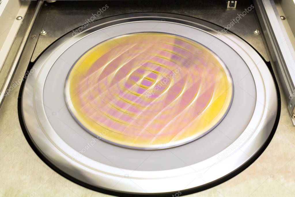 A microchip silicon wafer cleaning process that rotates at high speed. The substrate is blurred.