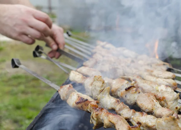 Cozinhar homem, apenas mãos, ele está cortando carne ou bife para um prato. Deliciosa carne grelhada na grelha. Fim de semana de churrasco . — Fotografia de Stock