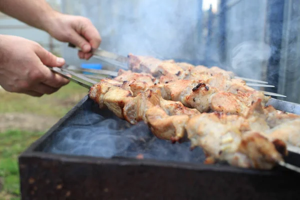 L'homme cuisine, seulement les mains, il coupe de la viande ou du steak pour un plat. Délicieuse viande grillée sur le gril. Week-end barbecue . — Photo