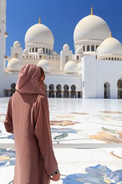 Abu Dabi, Uae - 11 Mart 2019: Şeyh Zayed Camii 'nde geleneksel kahverengi elbiseli kadın. Abu Dabi, Birleşik Arap Emirlikleri.